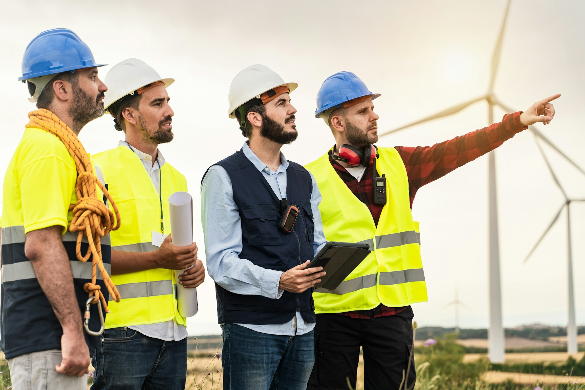 Professional workers working in front of windmill Electricity station